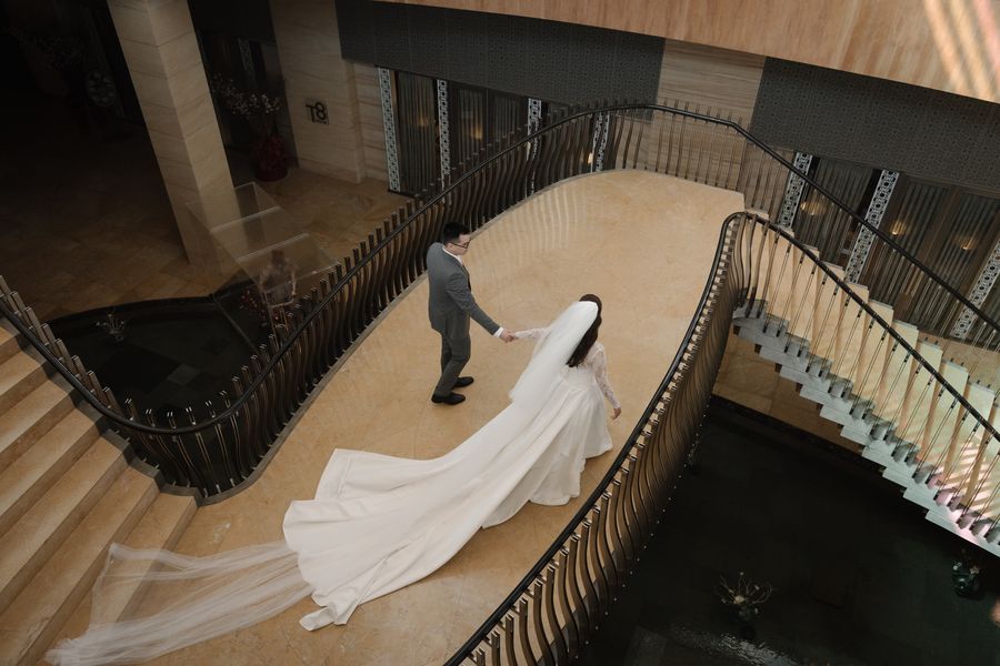A bride's gown trailing down a grand spiral staircase
