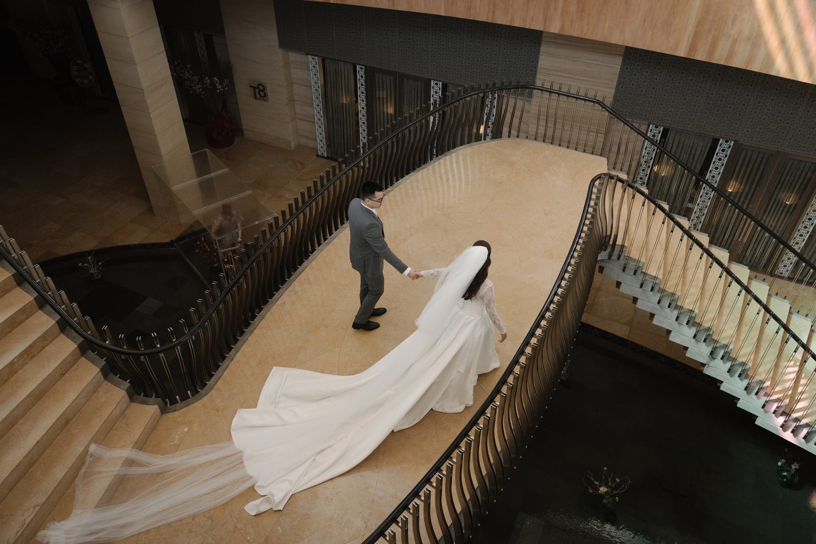 A bride's gown trailing down a grand spiral staircase