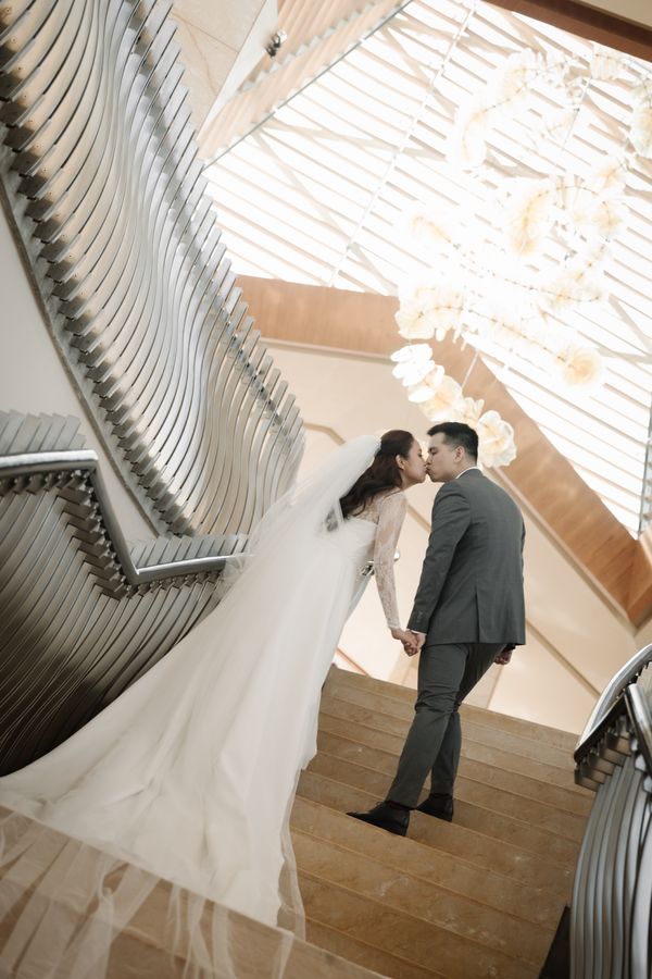 A couple framed by soft window light on their wedding day