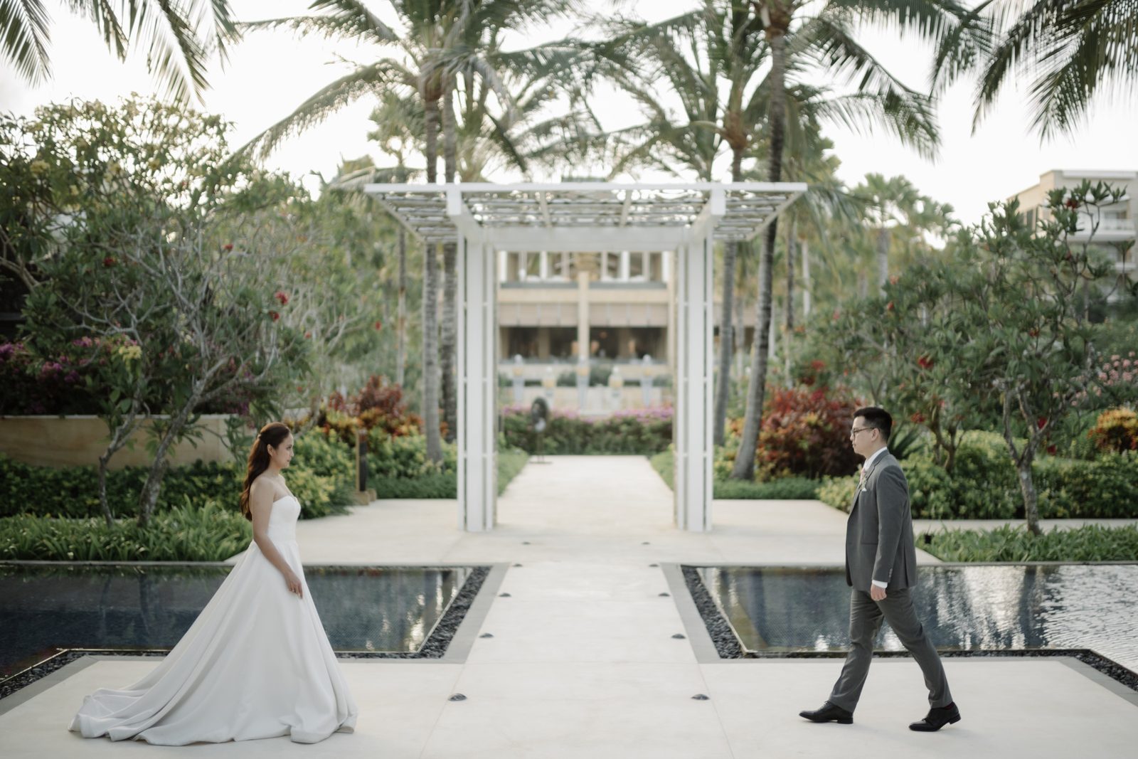A couple walking toward a grand columned venue on their wedding day