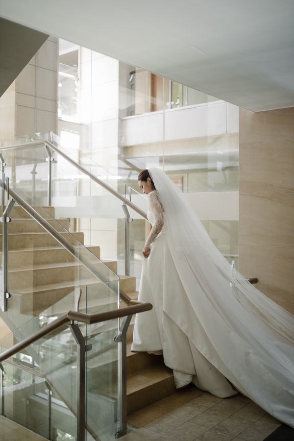 The bride on a glass staircase in her gown